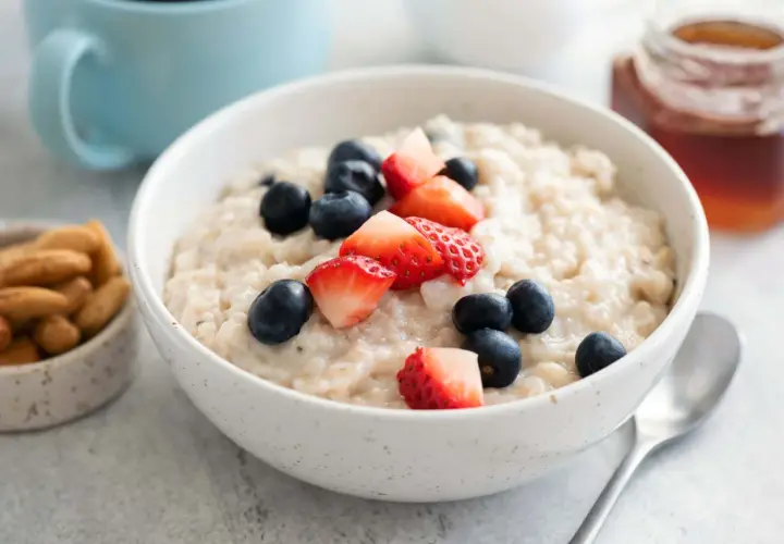 Haferbrei mit Beeren und Nüssen. Bei Darmentzündung was essen? Leichte Kost wie dieser Brei ist gut verträglich.