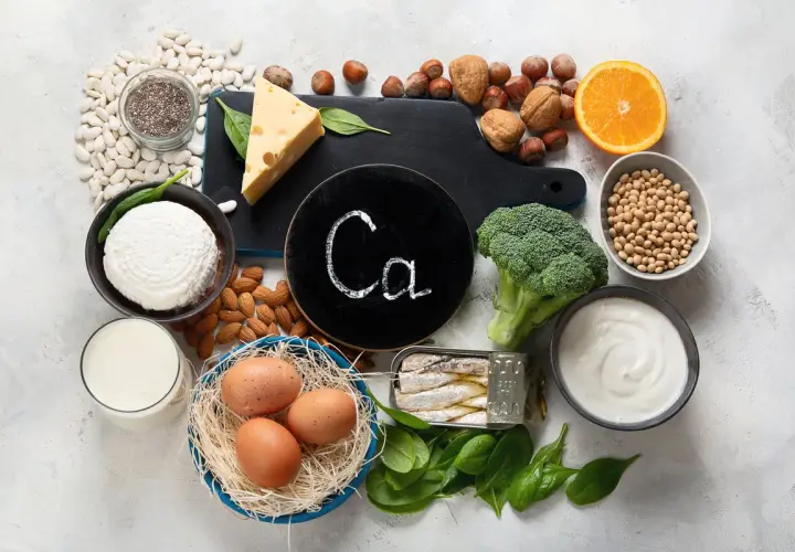 Eine **Calcium-Lebensmittel-Tabelle** mit Milch, Käse, Joghurt, Bohnen, Brokkoli, Mandeln, Sardinen, Eiern, Orangen und Chia-Samen.
